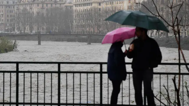 Passanti osservano il torrente Bisagno carico d'acqua. Allerta gialla su tutta la regione, qualche allagamento in città'. Genova, 02 Marzo 2020. ANSA/LUCA ZENNARO