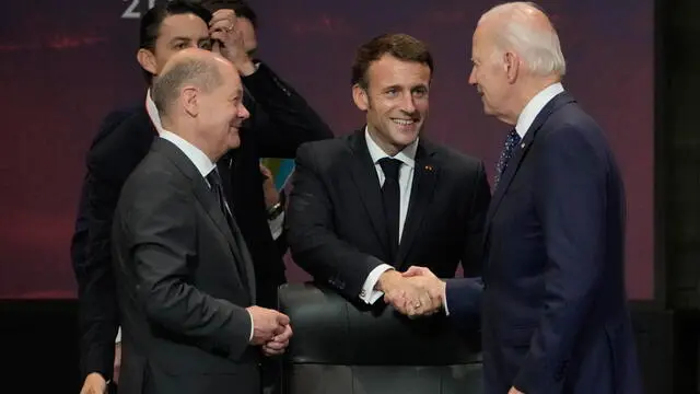 epa10306699 US President Joe Biden (R) shakes hands with French President Emmanuel Macron (C) while German Chancellor Olaf Scholz looks on during the G20 Leaders' Summit in Bali, Indonesia, 15 November 2022. The 17th Group of Twenty (G20) Heads of State and Government Summit runs from 15 to 16 November 2022. EPA/DITA ALANGKARA / POOL