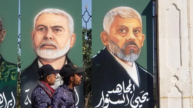 epa11666294 Houthi supporters walk past paintings showing the two late leaders of Hamas Yahya Sinwar (R) and Ismail Haniyeh during a rally in solidarity with the Lebanese and Palestinian people, one day after Hamas leader Yahya Sinwar was killed in Gaza, in Sana'a, Yemen, 18 October 2024. The Israeli Army, Tsahal, on 17 October 2024 confirmed that Hamas leader Yahya Sinwar was 'eliminated' on 16 October 'after a year-long pursuit'. Ismail Haniyeh was targeted and killed in Tehran, Iran, on 31 July 2024, the Iranian Revolutionary Guard Corps (IRGC) confirmed. Thousands of people participated in the rally in solidarity with the Lebanese and Palestinian people and to condemn the US support for Israel's military operations in Lebanon and the Gaza Strip, amid high tensions in the Middle East. EPA/YAHYA ARHAB