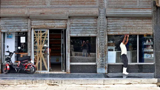 epa11667649 A man closes a store due to the lack of electricity in Havana, Cuba, 18 October 2024. The Cuban government suspended non-essential state work activities starting this 18 October as part of the measures announced the day before to address the current energy crisis. EPA/Ernesto Mastrascusa