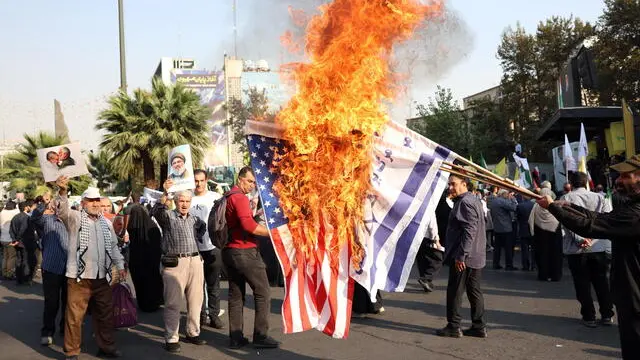 epa11649315 A portrait of late Hezbollah leader Hasan Nasrallah is held up as Iranians burn US and Israel flags during an anti-Israel rally protests at Palestine Square in Tehran, Iran, 08 October 2024. Tensions are growing between Iran and Israel following Iran's large-scale missile attack on Israel. Iran fired more than 180 ballistic missiles directed at Israel late on 01 October 2024, in 'retaliation for different assassinations' carried out by Israel and 'the crimes in Palestine and Lebanon', Islamic Revolutionary Guard Corps (IRGC) said. Israel's prime minister Benjamin Netanyahu said that Iran will pay for the 'big mistake'. EPA/ABEDIN TAHERKENAREH