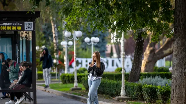 epa11669077 A young girl waits for her bus in front on National Opera in downtown Chisinau, Moldova, 19 October 2024. Moldova will hold presidential elections on 20 October 2024. EPA/DUMITRU DORU