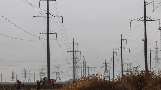 Workers repair high-voltage power lines cut by recent missile strikes near Odessa on December 7, 2022, amid the Russian invasion of Ukraine. - A new barrage of Russian strikes on December 5, left several Ukrainian cities without power, including the eastern city of Sumy and the southern city of Mykolaiv, according to officials. In Odessa, the water services operator said "there is no water supply anywhere" and officials in the central city of Kryvyi Rig said "parts of the city are cut off from electricity, several boiler and pumping stations are disconnected." (Photo by OLEKSANDR GIMANOV / AFP)