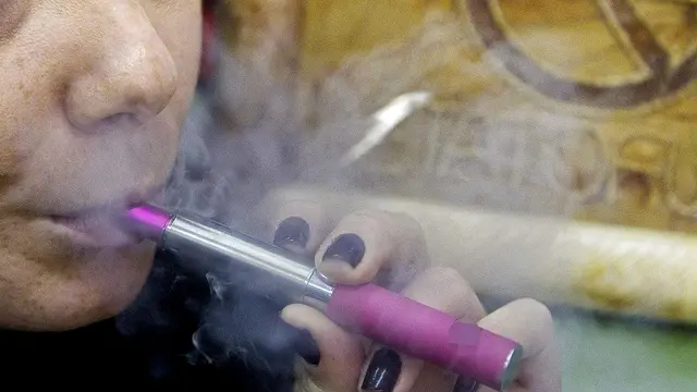 Una ragazza fuma una sigaretta elettronica in un locale pubblico a Roma. 27 dicembre 2012. Un mercato da circa 200 milioni di euro e che a fine anno dovrebbe più che raddoppiare con un numero di 'svapatori' (così si chiama chi usa le sigarette elettroniche o 'e-cig') che passerebbe dagli attuali 400.000 a circa 1 milione. Ma è solo l'inizio. Perché in Italia i fumatori tradizionali di 'bionde', incalliti o meno, sono circa 12 milioni. E i produttori delle e-sigarette credono fortemente nella potenzialità del fumo elettronico e nella ridotta nocività delle e-cig rispetto alle sigarette. ANSA/CLAUDIO PERI