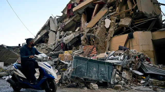 epa11672600 A man drives past the site of an Israeli airstrike that targeted a branch of the Al-Qard Al-Hassan finance group in Al-Shiyah, Beirut, Lebanon, 21 October 2024. The Israeli military said the air forces conducted late on 20 October a series of targeted strikes against dozens of facilities and sites used by Al-Qard al-Hassan Association, an organization used by Hezbollah to finance its activities. The strikes were conducted in the areas of Beirut, southern Lebanon, and Baalbek. According to the Lebanese Ministry of Health, more than 2,460 people have been killed and over 11,500 others have been injured in Lebanon since the start of recent escalations of hostilities. EPA/WAEL HAMZEH