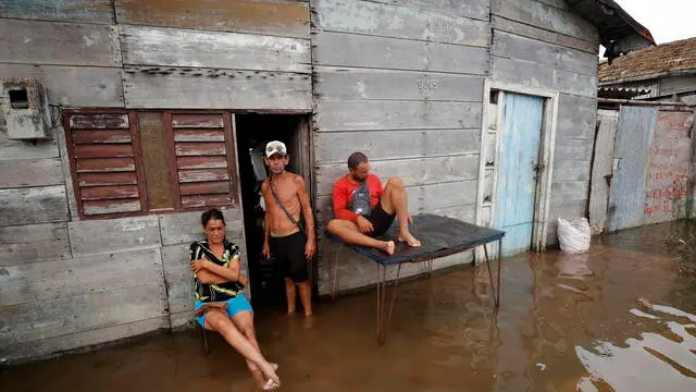 epa11651565 People rest in a street affected by flooding in Batabano, Cuba, 09 October 2024. Moderate flooding, power outages lasting over 10 hours, and residents using plastic buckets to remove water from their homes were some of the collateral effects in Cuba from Hurricane Milton's passage toward Florida, USA. EPA/Ernesto Mastrascusa