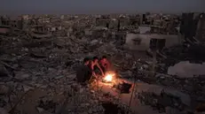 epaselect epa11671648 Palestinians sit next to a fire on the rubble of their destroyed home in Khan Yunis, southern Gaza Strip, 20 October 2024. More than 42,500 Palestinians and over 1,400 Israelis have been killed, according to the Palestinian Health Ministry and the Israel Defense Forces (IDF), since Hamas militants launched an attack against Israel from the Gaza Strip on 07 October 2023, and the Israeli operations in Gaza and the West Bank that followed it. EPA/HAITHAM IMAD