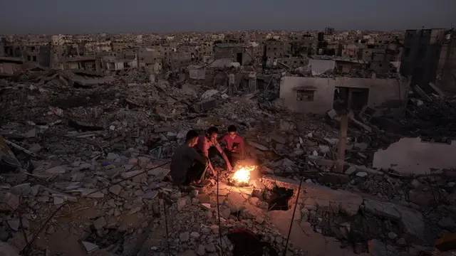 epaselect epa11671648 Palestinians sit next to a fire on the rubble of their destroyed home in Khan Yunis, southern Gaza Strip, 20 October 2024. More than 42,500 Palestinians and over 1,400 Israelis have been killed, according to the Palestinian Health Ministry and the Israel Defense Forces (IDF), since Hamas militants launched an attack against Israel from the Gaza Strip on 07 October 2023, and the Israeli operations in Gaza and the West Bank that followed it. EPA/HAITHAM IMAD