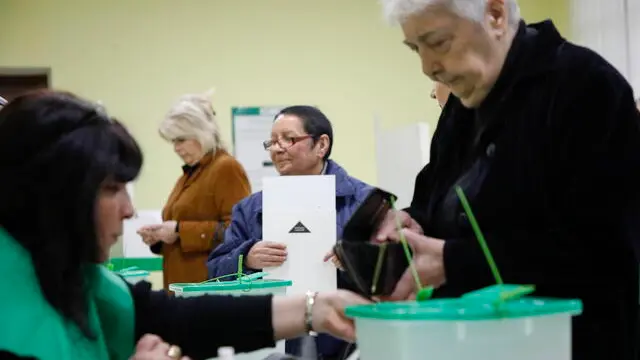 epa11684075 Georgian people cast their ballots during parliamentary elections, at a polling station in Tbilisi, Georgia, 26 October 2024. A total of 18 parties are participating in the parliamentary elections in Georgia. Three thousand, one hundred and eleven polling stations opened for the parliamentary elections, including 67 abroad. Voting abroad will be possible in 53 cities in 42 countries. EPA/DAVID MDZINARISHVILI