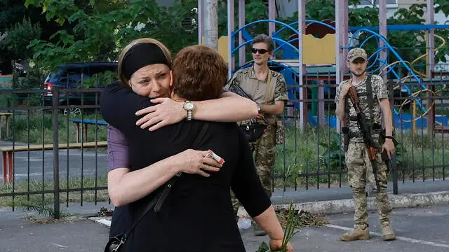 epa11472008 Relatives, friends, and colleagues attend a farewell ceremony for Viktor Bragutsa, the doctor who was killed in a rocket attack on 08 July, near the ADONIS clinic in Kyiv, Ukraine, 11 July 2024. Russia massively attacked Ukraine with missiles on 08 July, striking Kyiv, Dnipro, Kryvyi Rih, Sloviansk, and Kramatorsk. More than 40 missiles of different types were launched, striking residential buildings, infrastructure, and a children's hospital. A total of 29 people have been killed, including four children, and 117 others injured, including 10 children, as a result of shelling in Kyiv on 08 July, Ukraine's State Emergency Service said. EPA/SERGEY DOLZHENKO