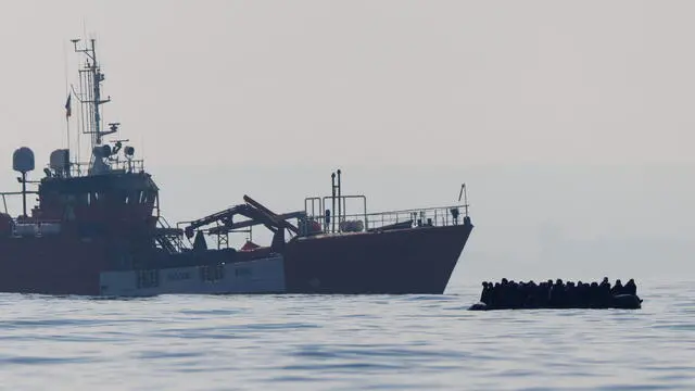 epa11202044 Migrants cross the English Channel on a small boat, with a French rescue ship in the background, on 06 March 2024. The UK government has suffered more setbacks at the House of Lords recently on its plan to send migrants to Rwanda to deter the Channel crossings. Despite the British and French government's efforts to prevent migrants from making the dangerous journey on small boats, many are willing to take the risk to claim asylum in the UK. EPA/TOLGA AKMEN