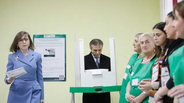 epa11684229 Georgian oligarch Bidzina Ivanishvili (C) and his wife Ekaterine Khvedelidze (L) cast their ballots during parliamentary elections, at a polling station in Tbilisi, Georgia, 26 October 2024. A total of 18 parties are participating in the parliamentary elections in Georgia. Three thousand, one hundred and eleven polling stations opened for the parliamentary elections, including 67 abroad. Voting abroad will be possible in 53 cities in 42 countries. EPA/DAVID MDZINARISHVILI