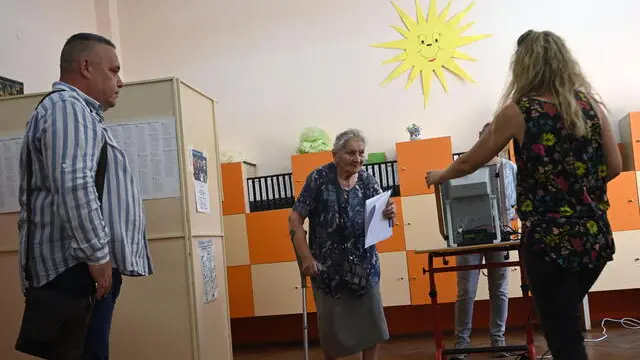 epa11398935 A woman (C) votes at a polling station during the country's parliamentary elections and the European elections in Sofia, Bulgaria, 09 June 2024. Bulgaria votes for a national and European parliament. The sixth consecutive election in the last four years was held after the leaders of GERB (Citizens for European Development of Bulgaria) and 'We Continue the Change - Democratic Bulgaria' (PP-DB) did not reach an agreement on their joint governance. EPA/VASSIL DONEV