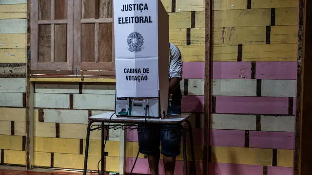 epa11646301 A resident of the Catalao community votes during the Brazilian municipal elections in Iranduba, Amazonas, Brazil, 06 October 2024. Catalao, a community made up solely of houseboats, is isolated by a small portion of water, as residents managed to build a dam. Drought in the Amazon rivers has made it difficult for voters to move around the region. More than 750,000 people are affected by the drought. EPA/Raphael Alves