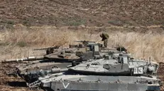 epa11627948 An Israeli soldier stands on a tank as they gather at an undisclosed location in northern Israel, 27 September 2024. Israel's military stated on 27 September, that the Israel Air Force (IAF) launched dozens of strikes targeting Hezbollah cells and infrastructure in several areas in southern Lebanon. EPA/ATEF SAFADI