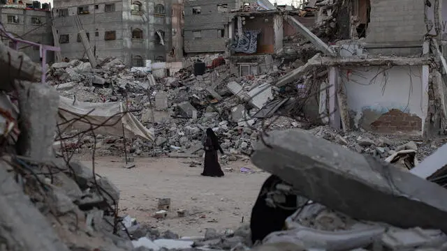 epa11671672 A Palestinian woman walks past destroyed homes in Khan Yunis, southern Gaza Strip, 20 October 2024. More than 42,500 Palestinians and over 1,400 Israelis have been killed, according to the Palestinian Health Ministry and the Israel Defense Forces (IDF), since Hamas militants launched an attack against Israel from the Gaza Strip on 07 October 2023, and the Israeli operations in Gaza and the West Bank that followed it. EPA/HAITHAM IMAD