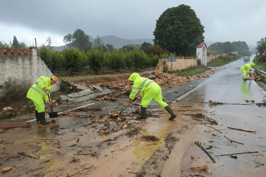 epaselect epa11690258 Several workers cleans the approach road to the village of Manuel after torrential rainfalls, in Valencia, eastern Spain, 29 October 2024. Heavy rains are hitting the region during the day. EPA/NATXO FRANCES