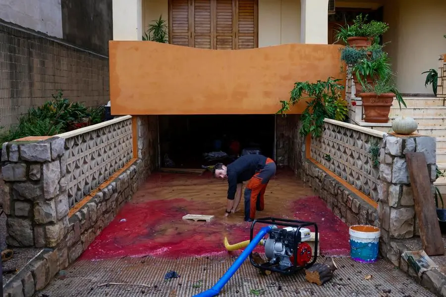 epa11690553 A man cleans the entrance of his home after flooding in Llombai, Valencia, Spain, 29 October 2024. The State Meteorological Agency (AEMET) has activated red alerts for rain in various areas of the province of Valencia due to heavy rainfall caused by the storm DANA that is hitting several areas of Spain. EPA/ANA ESCOBAR