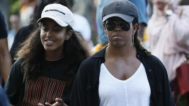 epa06052199 Former US First Lady Michelle Obama (R) and her daughter Malia Obama (L) visit the Tirta Empul Temple during a family holiday in Bali, Indonesia, 27 June 2017. The Obamas are in Bali as part of a ten-day family holiday in Indonesia. EPA/MADE NAGI