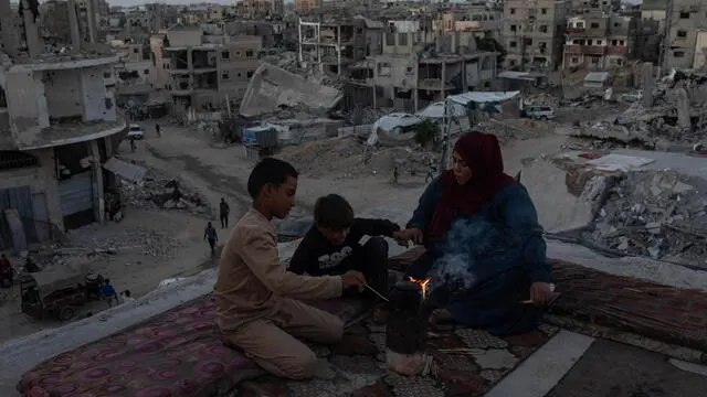 epa11634230 Members of a Palestinian family gather around a fire on the roof of their destroyed house in Khan Yunis, southern Gaza Strip, 30 September 2024. The ongoing conflict has left the population with widespread destruction, including the disruption of basic services such as water, electricity and sanitation. More than 41,300 Palestinians and over 1,400 Israelis have been killed, according to the Palestinian Health Ministry and the Israel Defense Forces (IDF), since Hamas militants launched an attack against Israel from the Gaza Strip on 07 October 2023, and the Israeli operations in Gaza and the West Bank which followed it. EPA/HAITHAM IMAD