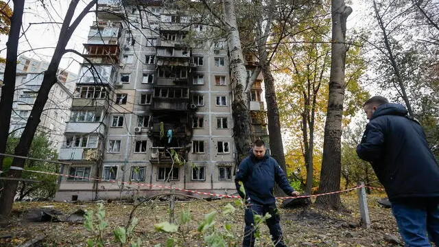 epa11691950 People stand near the site of an overnight drone attack on a residential area in the Solomyansk district of Kyiv, Ukraine, 30 October 2024. At least nine people were injured when debris of a downed drone fell on a residential building following a drone attack, the State Emergency Service of Ukraine (SESU) reported. According to the Ukrainian Armed Forces, Russian troops launched an overnight attack with 62 'Shahed' unmanned aerial vehicles (UAVs) across Ukraine. EPA/SERGEY DOLZHENKO