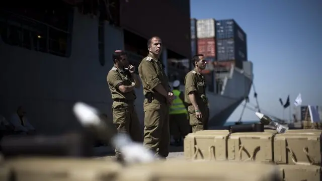 epa02636533 Soldiers backdropped by the cargo ship 'Victoria' guard seized mortar shells in the port in the southern Israeli city of Ashdod, on 16 March 2011. Israel Navy seized the ship which IDF said contained 'tons' of concealed weapons destined for 'use of terror organization operating in Gaza Strip.' The boat was towed to the Ashdod port for further inspection. EPA/OLIVER WEIKEN