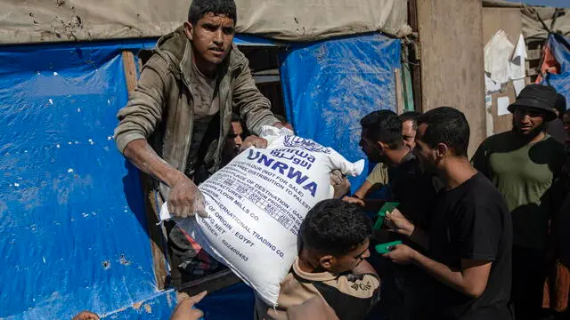 epa11693849 People distribute bags of flour to Palestinians at a United Nations Relief and Works Agency for Palestine Refugees in the Near East (UNRWA) aid distribution center in Khan Younis, southern Gaza Strip, 31 October 2024. According to the UN, at least 1.9 million people (or nine in ten people) across the Gaza Strip are internally displaced, including people who have been repeatedly displaced. Since October 2023, only about 11 percent of the Gaza Strip has not been placed under Israeli-issued evacuation orders, the UN aid coordination office OCHA said. EPA/HAITHAM IMAD