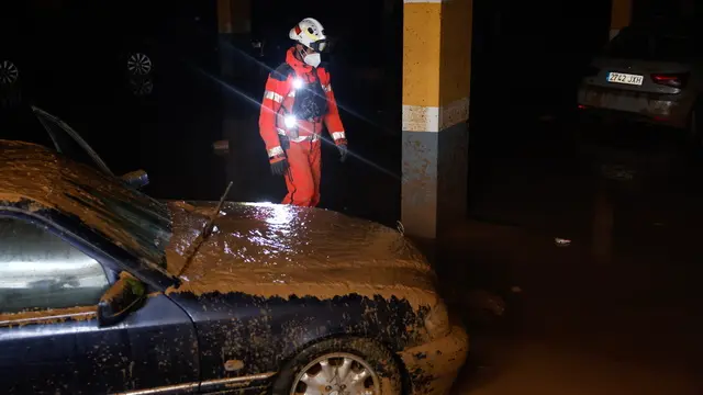 epa11700585 A firefighter stands next to a mud-covered car while searching for victims at an underground parking lot, in the municipality of Sedavi, province of Valencia, Spain, 04 November 2024. The devastating floods in Valencia and neighboring provinces have caused at least 213 fatalities as efforts to search for missing people, provide supplies and care for the victims continue almost one week since the DANA (high-altitude isolated depression) weather phenomenon hit the east of the country. EPA/ANA ESCOBAR