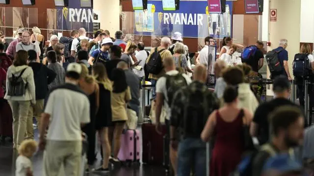 epa10072328 Passengers wait in line at the check-in desk at Josep Tarradellas Barcelona-El Prat Airport in Barcelona, Spain, 15 July 2022. Some 10 flights were canceled and 15 others were delayed at the airport due to strikes called by Ryanair and EasyJet airlines' crew. EPA/ALEJANDRO GARCIA