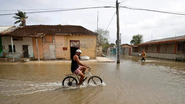 epa11651563 A man rides a bicycle on a flooded street in Batabano, Cuba, 09 October 2024. Moderate flooding, power outages lasting over 10 hours, and residents using plastic buckets to remove water from their homes were some of the collateral effects in Cuba from Hurricane Milton's passage toward Florida, USA. EPA/Ernesto Mastrascusa