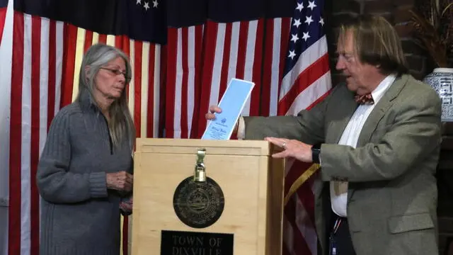 epa08210234 Deborah Tillotson (L) hands her ballott to town moderator Tom Tillotson (R) as the five registered voters cast their ballots in the first-in-the-nation presidential primary moments after midnight, in the small village of Dixville Notch, New Hampshire, USA, 11 February 2020. EPA/HERB SWANSON