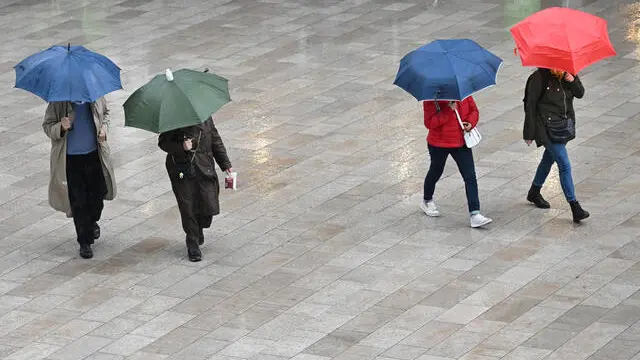 Persone si riparano dalla pioggia con ombrelli per l'intensa pioggia , Milano, 24 ottobre 2023. Fino al weekend due perturbazioni raggiungeranno l'Italia e la prima, la più forte, è già in atto in queste ore. Da oggi fino al fine settimana, dunque, l'Italia verrà raggiunta da due perturbazioni, con venti di Libeccio con raffiche fino a 70-80 km/h. Ci saranno mareggiate sulle coste esposte e il Mar Ligure sarà agitato, mossi o molto mossi gli altri bacini. ANSA/DANIEL DAL ZENNARO