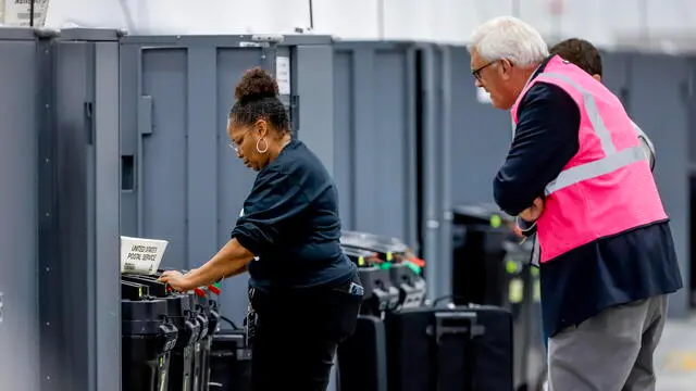 epa11704295 A Republican Party election monitor (R) watches a Fulton County Department of Registration & Elections worker (L) pull memory cards for tabulation from Early Voting machines at the county's new Elections Hub and Operations Center in Union City, Georgia, USA, 05 November 2024. Voters across the country are casting ballots today for President of the United States in a tightly contested race between Republican presidential candidate Donald J. Trump and Democratic presidential candidate US Vice President Kamala Harris, as well as for candidates in Senate and Congressional races. EPA/ERIK S. LESSER