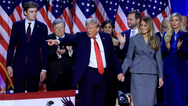 epa11704650 Republican presidential candidate Donald J. Trump (C), joined on stage by his wife Melania Trump and their son Barron Trump (L), addresses supporters at the Election Night watch party in the West Palm Beach Convention Center in West Palm Beach, Florida, USA, 06 November 2024. EPA/CRISTOBAL HERRERA-ULASHKEVICH