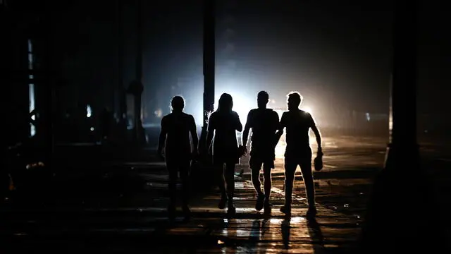 epaselect epa11673371 People walk down a street during a blackout, in Havana, Cuba, 20 October 2024 (issued 21 October 2024). The restoration of electricity in the affected areas of Cuba, including Havana, is in progress, after Cuba's Ministry of Energy and Mines reported on 20 October a third total failure of the National Electric System (SEN) in less than three days. EPA/ERNESTO MASTRASCUSA