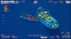 L'indagine della Procura di Agrigento che oggi ha portato al fermo di 9 persone accusate di traffico di uomini nasce da una operazione del dispositivo interforze dell'Agenzia Europea Frontex, della Guardia di Finanza, delle Capitanerie di Porto e della missione EUNAVFORMED. Un aereo, ieri, ha documentato, a circa 60 miglia a sud dell'isola di Lampedusa, il trasbordo di un gruppo di migranti da un motopesca su di una imbarcazione più piccola. Dopo il trasbordo, la nave madre si è allontanata puntando verso la Libia. ANSA/FERMO IMMAGINE FRONTEX +++ ANSA PROVIDES ACCESS TO THIS HANDOUT PHOTO TO BE USED SOLELY TO ILLUSTRATE NEWS REPORTING OR COMMENTARY ON THE FACTS OR EVENTS DEPICTED IN THIS IMAGE; NO ARCHIVING; NO LICENSING +++