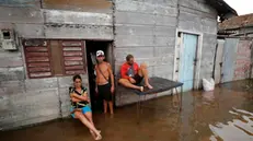 epaselect epa11651565 People rest in a street affected by flooding in Batabano, Cuba, 09 October 2024. Moderate flooding, power outages lasting over 10 hours, and residents using plastic buckets to remove water from their homes were some of the collateral effects in Cuba from Hurricane Milton's passage toward Florida, USA. EPA/Ernesto Mastrascusa