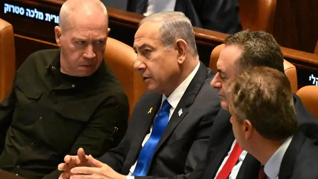 epa11689135 Israeli Prime Minister Benjamin Netanyahu (C) speaks to Defense Minister Yoav Gallant (L) at the opening of the 25th Knesset session in Jerusalem, 28 October 2024. Israel opened its Knesset session marking the anniversary of the 'Swords of Iron' war, Israel's ground operations in the Gaza Strip. More than 43,000 Palestinians and over 1,400 Israelis have been killed, according to the Palestinian Health Ministry and the Israel Defense Forces (IDF), since Hamas militants launched an attack against Israel from the Gaza Strip on 07 October 2023, and the Israeli operations in Gaza and the West Bank which followed it. EPA/DEBBIE HILL / POOL