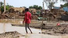 epa10135163 Sudanese people stand amid a flooded area of Al Jazirah state, Sudan, 23 August 2022. According to the Sudanese Council for Civil Defense, at least 79 people died in incidents related to the recent floods in the country. Thousands of homes were damaged due to the floods that affected South Darfur, North Kordofan, and Al Jazirah state. EPA/MOHND AWAD