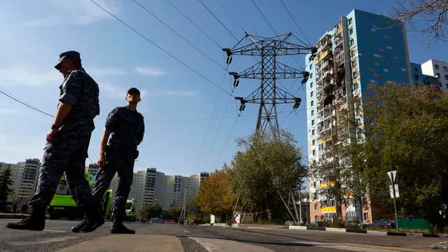 epa11595932 Russian policemen stand guard near a damaged apartment building following an alleged Ukrainian drone attack in Ramenskoye, Moscow region, Russia, 10 September 2024. A 46-year-old woman died in an overnight drone attack on Ramenskoye outside Moscow, the Moscow region's Governor Andrey Vorobyov said. EPA/YURI KOCHETKOV