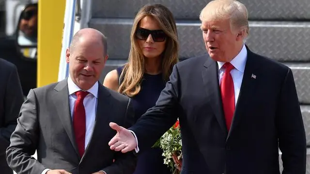 epa06070184 US President Donald J. Trump (R) and his wife, Melania Trump (C), are welcomed by First Mayor of Hamburg Olaf Scholz (L) as they arrive at Hamburg Airport ahead of the G20 summit in Hamburg, Germany, 06 July 2017. The G20 Summit (or G-20 or Group of Twenty) is an international forum for governments from 20 major economies. The summit is taking place in Hamburg 07 to 08 July 2017. EPA/LUKAS BARTH