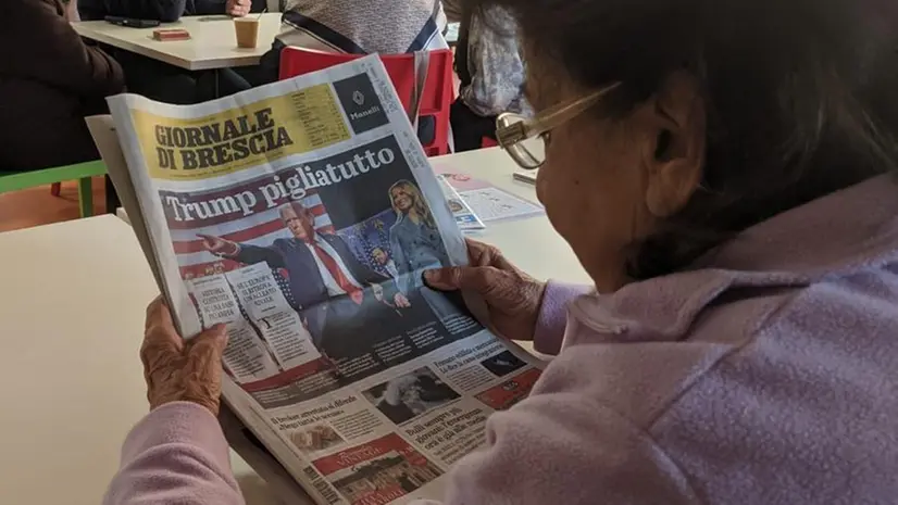 Una donna legge il quotidiano al centro aperto di Mompiano degli Alberi di Vita