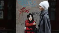 Il murale dedicato a Giulia Cecchettin realizzato a Milano dell'artista Fabio Ingrassia, 02 dicembre 2023. Giulia è raffigurata mentre si abbraccia, avvolta in un cappotto rosso con un messaggio sulla tasca: ''Volevo solo scomparire in un abbraccio''. ANSA/ PAOLO SALMOIRAGO