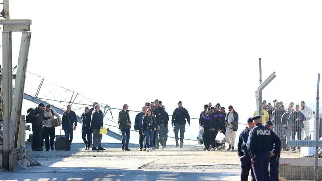 epa11709513 A group of migrants (R) intercepted in international waters around Italy, disembark the Italian Navy vessel Libra at Shengjin, Albania, 08 November 2024. Italy has sent a group of 8 migrants to Albania, after a previous group was turned away in October for failing the vetting process, in a plan aimed at deterring dangerous sea crossings by processing asylum claims outside the EU. The initiative faced legal setbacks after Italian courts ruled that migrants could not be held in Albania due to concerns over their legal status. In response, the Italian government adjusted the legal framework, hoping this would strengthen the policy, which allows up to 3,000 non-vulnerable men to be housed temporarily in Italian-run facilities in Albania. EPA/MALTON DIBRA