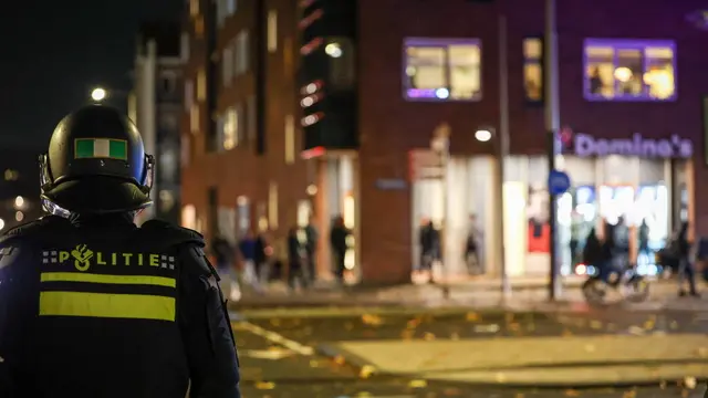 epa11715448 Anti riot police stand guard at the scene after a group caused a commotion on Plein 40-45 in Amsterdam Nieuw-West, The Netherlands, 11 November 2024. In the disturbances, a burning object landed on a streetcar and caught fire, but was extinguished. There were no people in the streetcar and no injuries were reported. EPA/TALHA ANDAC