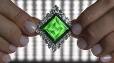 epa11707938 A Christie's employee displays the Aga Khan Emerald, a Cartier emerald and diamond brooch, 1960, a square-shaped of 37.00 carats, marquise-shaped diamonds, platinum and 18k yellow gold, 4.9 cm high, during a preview at Christie's auction house in Geneva, Switzerland, 07 November 2024. EPA/MARTIAL TREZZINI