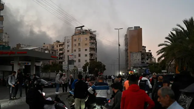 epa11721254 People watch as smoke rises following an Israeli airstrike in the Al-Chiyah area in southern Beirut, Lebanon, 14 November 2024. According to the Lebanese Ministry of Health, around 3,365 people have been killed and over 14,344 others have been injured in Lebanon since the escalation in hostilities between Israel and Hezbollah. EPA/WAEL HAMZEH