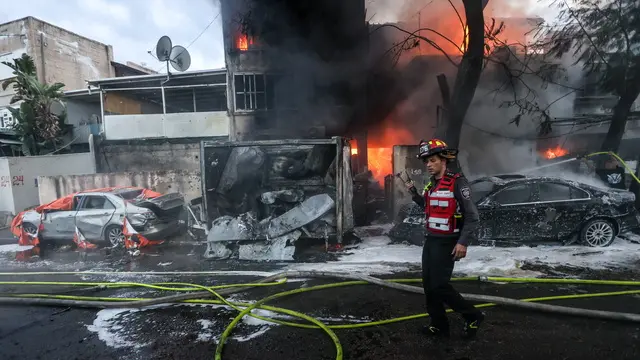 epa11715117 Israeli firefighters work to extinguish a fire after rockets fired from Lebanon hit the city of Kiryat Ata, Haifa District, northern Israel, 11 November 2024. The Israeli military stated that around 90 projectiles crossed from Lebanon into northern Israel, on 11 November, adding that most of them were intercepted by Israel's Iron Dome air defense system. According to the Magen David Adom (MDA), Israel's national emergency services, two people injured in the rocket hit in Kiryat Ata have been evacuated to Rambam hospital. EPA/GIL NECHUSHTAN ISRAEL OUT