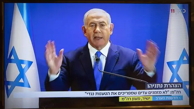 epa07268286 Israeli Prime Minister Benjamin Netanyahu speaks on television from his home in Jerusalem, 07 January 2019 as seen on a television set showing Israel's Channel One 8 PM news show. The embattled prime minister spoke about the alleged corruption charges he faces in the Israeli courts if charges are levelled against him. He spoke from his Jerusalem residence and no journalists were allowed into the residence. EPA/JIM HOLLANDER