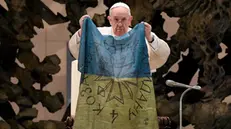 epa09873466 A handout picture provided by the Vatican Media shows Pope Francis holding a flag of Ukraine that was sent to him from the Ukrainian town of Bucha during the weekly general audience in the Paul VI Audience Hall, in Vatican City, 06 April 2022. The pontiff lamented the 'massacre of Bucha', in the Kyiv suburb where dozens of bodies in civilian clothing have been found, and renewed his calls for an end to the war in Ukraine. EPA/VATICAN MEDIA HANDOUT HANDOUT EDITORIAL USE ONLY/NO SALES